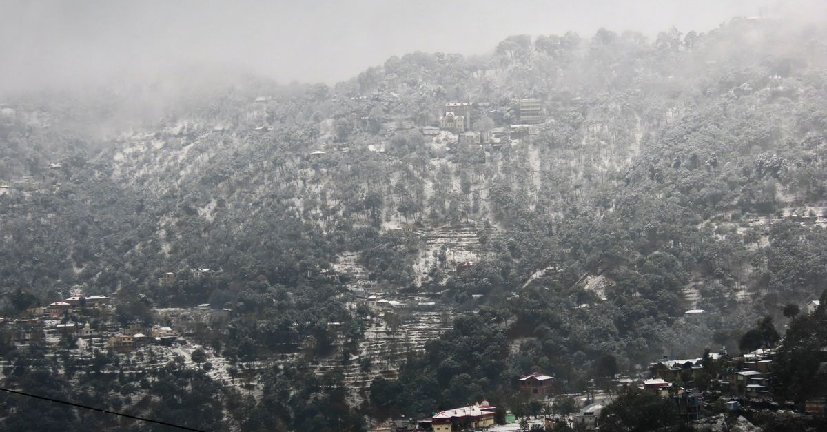 Snow-covered forested hills and mist over Kasauli, Himachal Pradesh